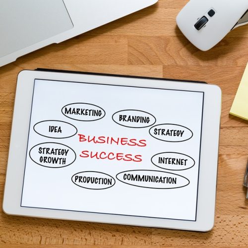 Modern working table with laptop computer with tablet showing marketing success concept